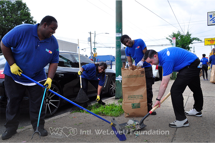 Volunteers sweeping up trash on Castor Avenue