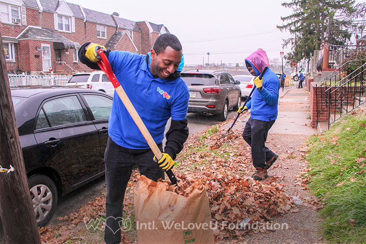 Two WeLoveU volunteers raking leaves in Northeast Philadelphia