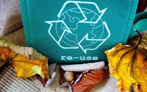 A green reusable bag that says 'reuse' on it
