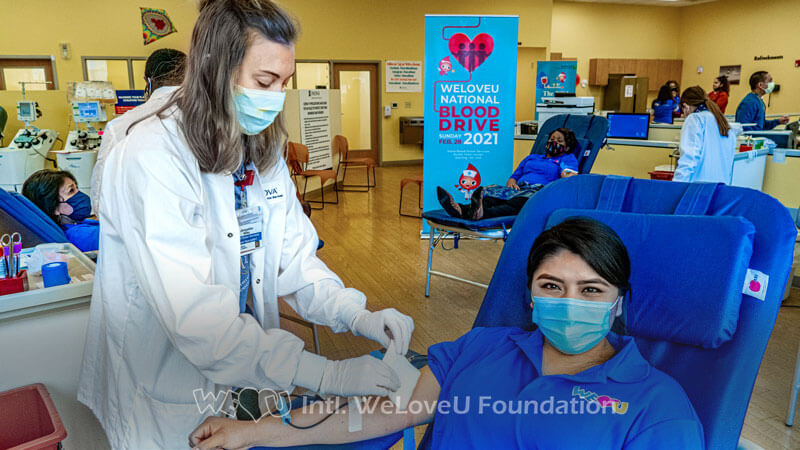 An Inova Blood Center staff attends a donor's arm
