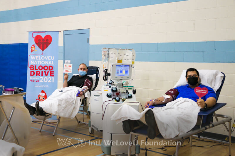 Two volunteers are donating blood