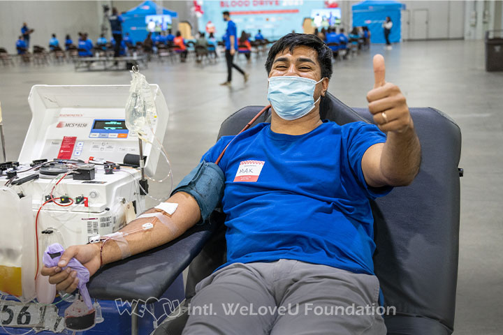 A WeLoveU volunteer flashes a thumbs up while donating blood in Atlanta, GA