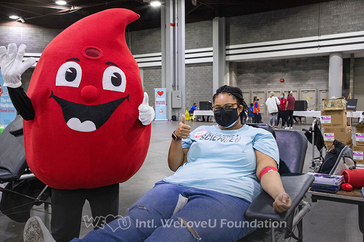 The American Red Cross mascot and blood donor give a thumbs up
