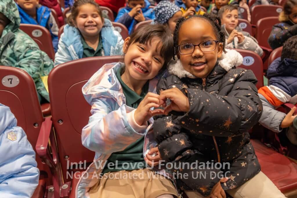 two elementary students make a heart together with their new winter coats on in new jersey school