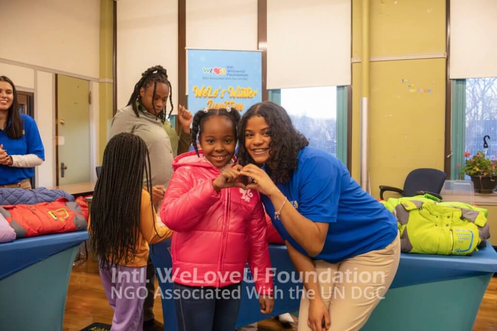 a student and weloveu volunteer make a heart with their hands