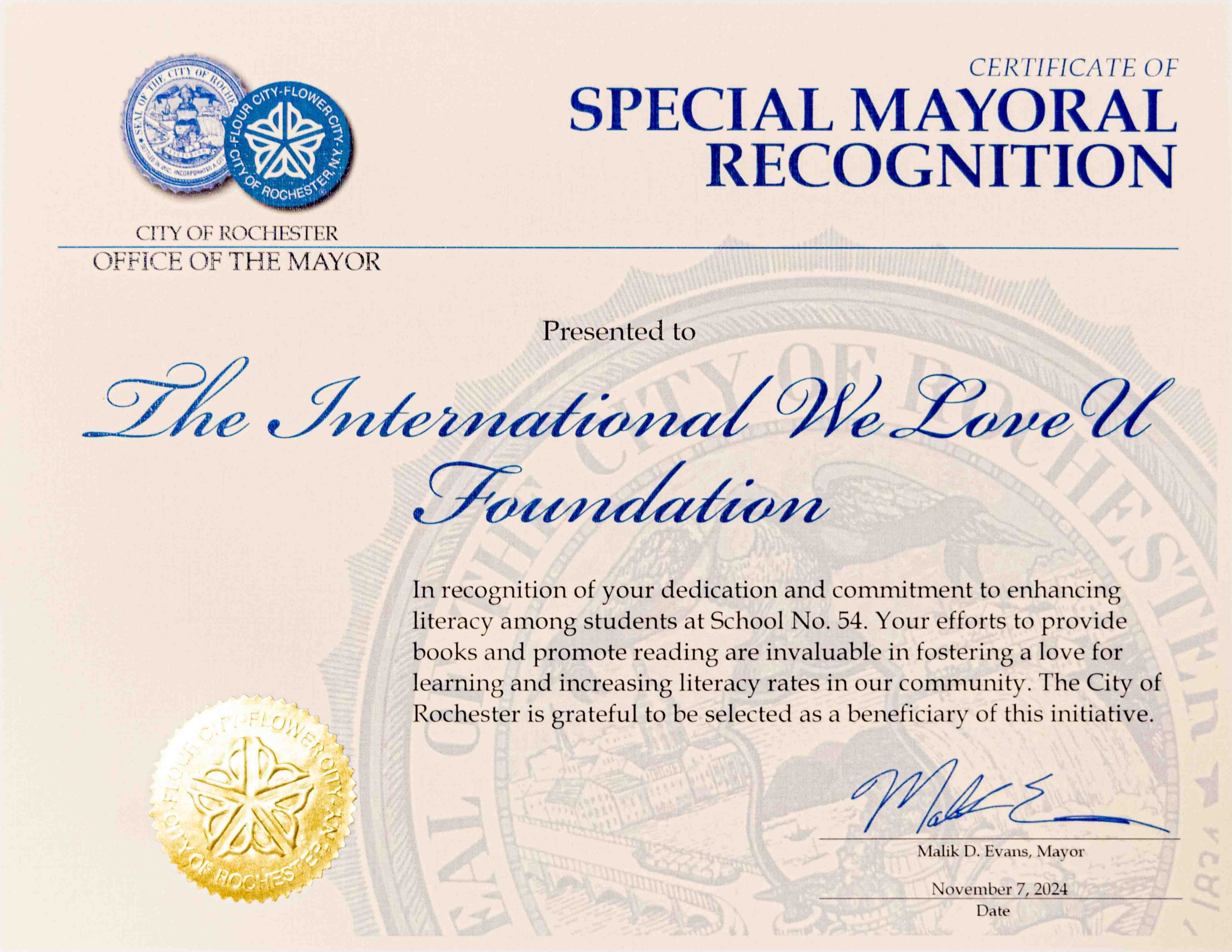 Rochester Mayor Malik Evans signs a certificate of special mayoral recognition to the weloveu foundation